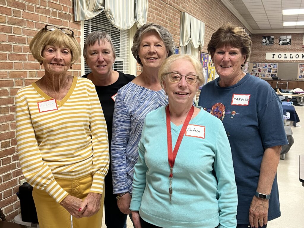 Five older Winter Relief volunteers smiling. Many volunteers have hosted Winter Relief for years. 