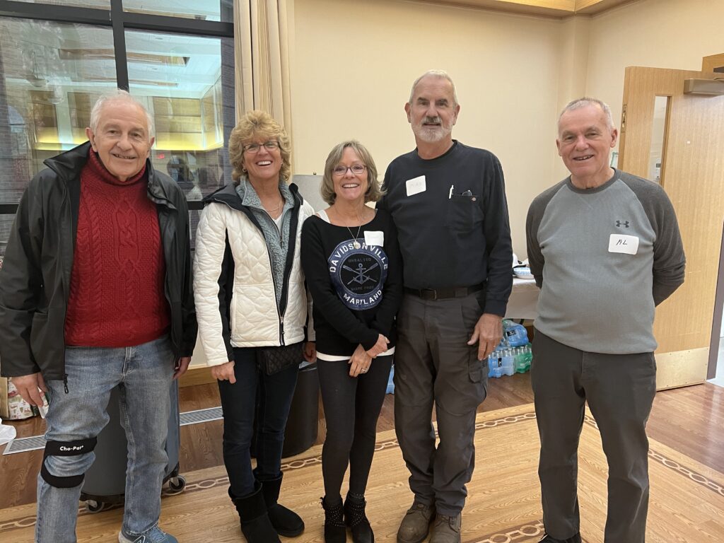 Two women and three men stand in a row smiling. Winter Relief volunteers dedicate many hours planning and executing the emergency shelter program in Anne Arundel County called Winter Relief